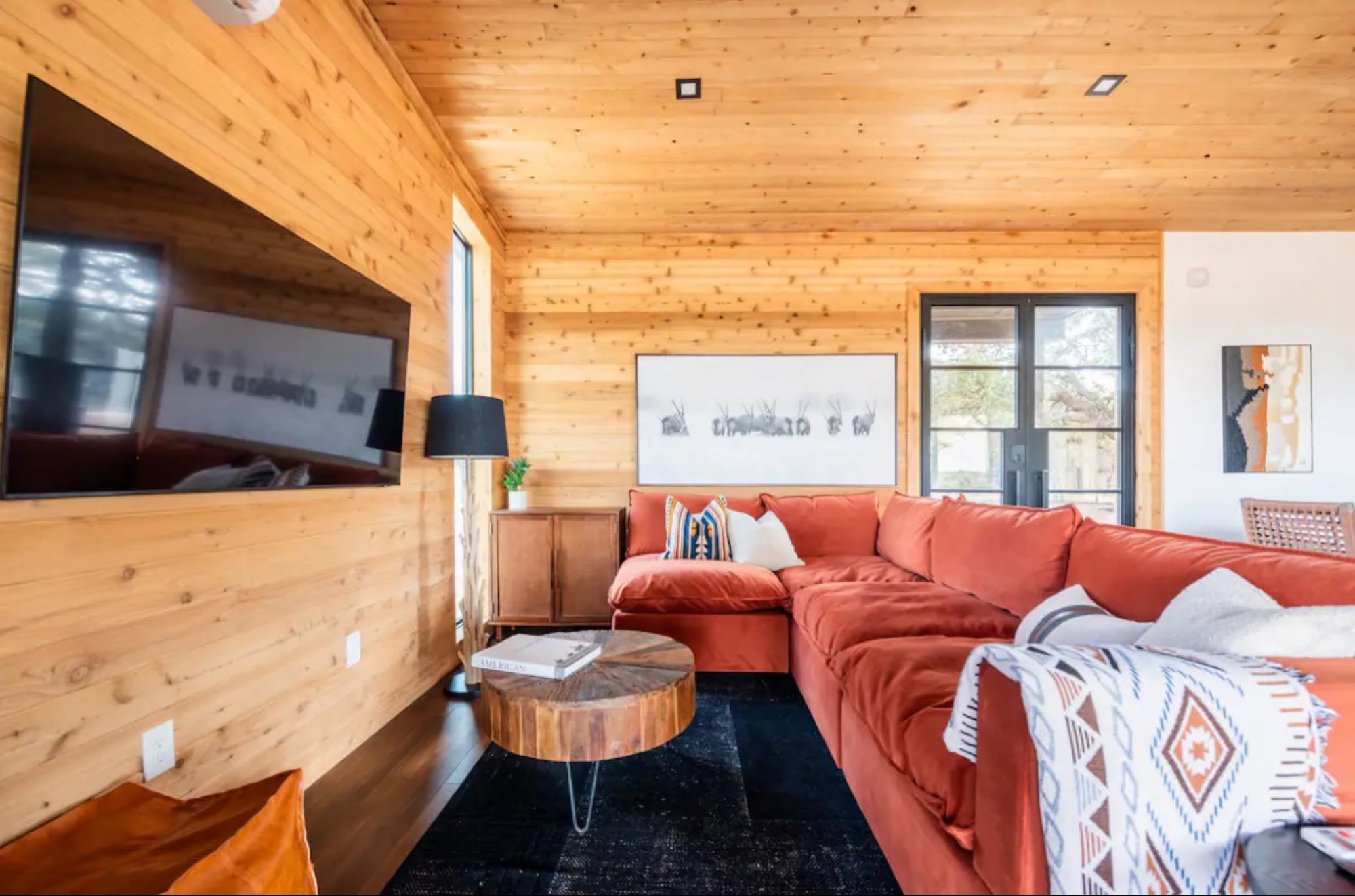 Living room with a rust-coloured sectional sofa under a cedar ceiling